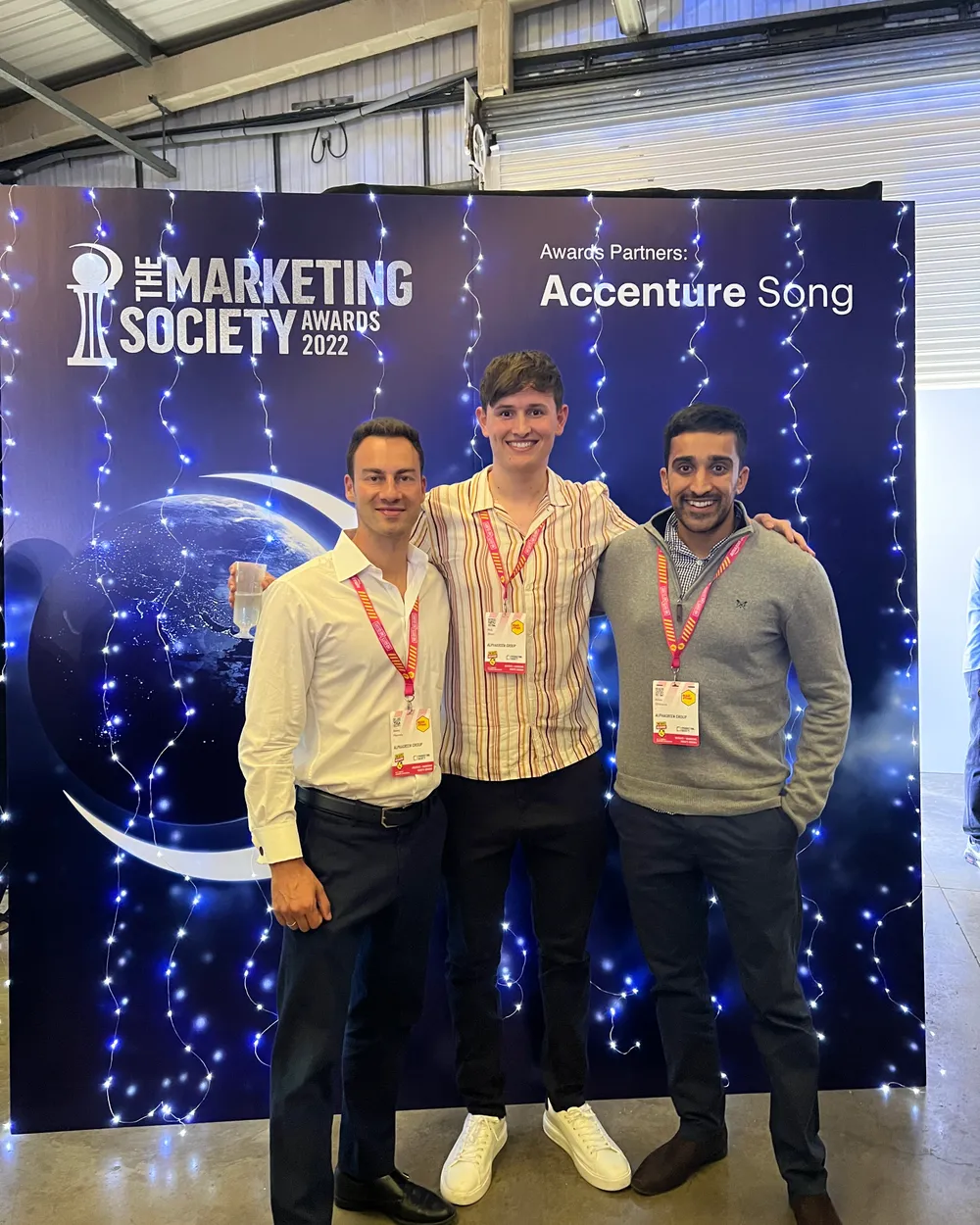 Alexej Pikovsky with two colleagues in front of The Marketing Society Awards 2022 backdrop